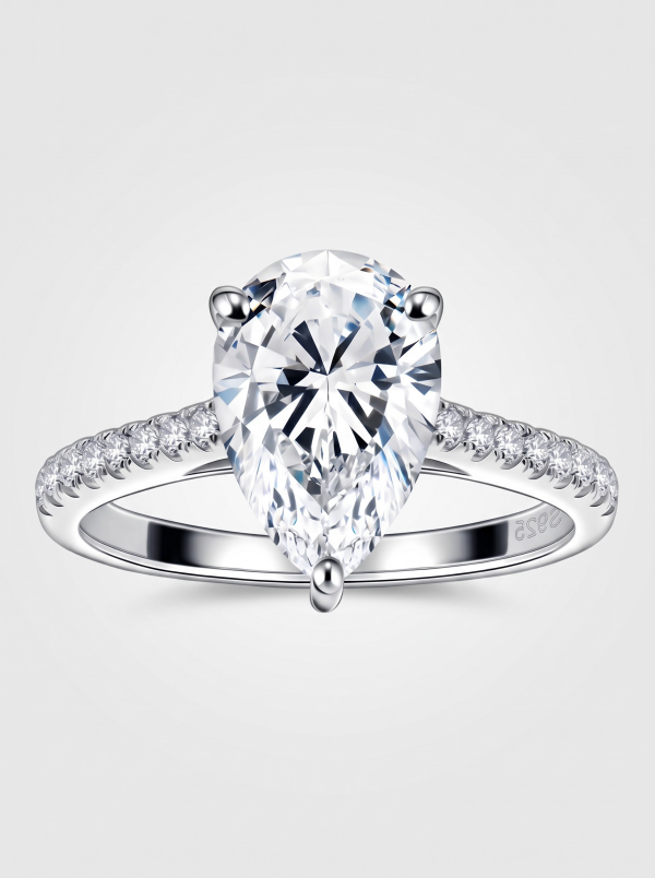 Pear cut moissanite ring with clear accents along the silver-tone band